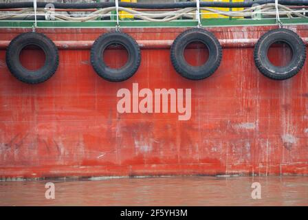 Seitenansicht eines Schleppers mit Gummireifen Auf der roten Stahlfassade Stockfoto