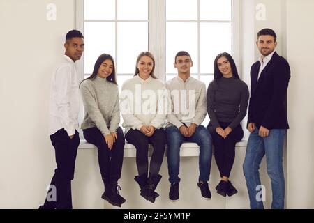 Glückliche junge multiethnische Studenten, Freunde oder Kollegen lächeln und schauen in die Kamera Stockfoto