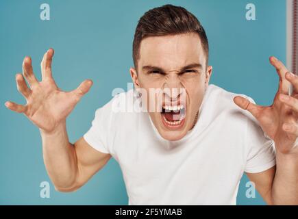 Verrückter Mann schreit auf blauem Hintergrund mit java Hände in Faust Stockfoto