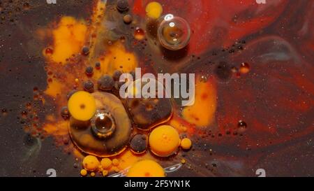 Tintenblasen gemischt mit flüssiger Substanz aus Öl, Milch, Seife, heller Acrylfarbe auf bunter Oberfläche Stockfoto