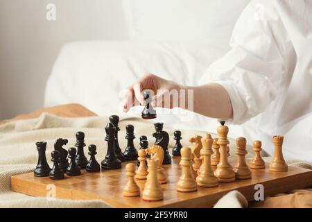 Schachspielerin Frau Lernt Schacheröffnung, Indem Sie Mit Sich Selbst Spielt. Schwarzer Bauer Einen Schritt Vorwärts. Schachbrett Aus Holz Mit Schachfiguren Auf Hellem Hintergrund. Strategie Board Spiel Gespielt. Nahaufnahme Stockfoto