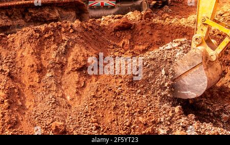 Bagger graben Boden auf der Baustelle. Eimer Bagger graben Boden. Raupenbagger graben auf Schmutz. Baggermaschine. Erdbeweger Stockfoto