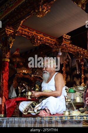 Ein balinesischer Hindu-Priester segnet einen Bräutigam in einer Vorhochzeit-Zeremonie in einem kleinen Tempel in Ubud, Bali, Indonesien. Stockfoto