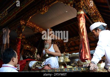 Ein balinesischer Hindu-Priester segnet einen Bräutigam in einer Vorhochzeit-Zeremonie in einem kleinen Tempel in Ubud, Bali, Indonesien. Stockfoto