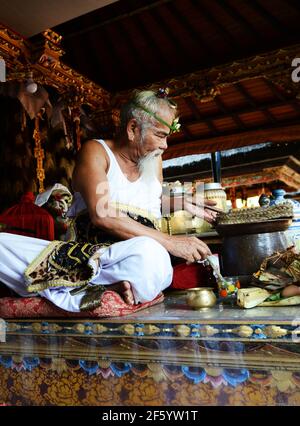 Ein balinesischer Hindu-Priester segnet einen Bräutigam in einer Vorhochzeit-Zeremonie in einem kleinen Tempel in Ubud, Bali, Indonesien. Stockfoto