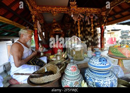 Ein balinesischer Hindu-Priester segnet einen Bräutigam in einer Vorhochzeit-Zeremonie in einem kleinen Tempel in Ubud, Bali, Indonesien. Stockfoto