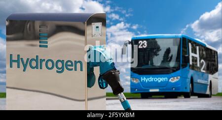 Touristenbus auf Wasserstoff-Kraftstoff mit H2-Tankstelle an Ein Hintergrund von grünem Feld und blauen Himmel Stockfoto