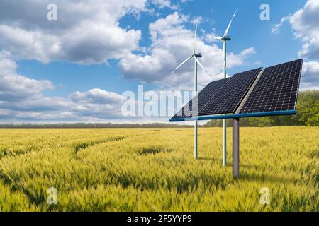 Sonnenkollektoren und Windturbinen auf einem grünen Feld. Nachhaltiges Energiekonzept Stockfoto