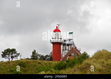 Der rote Leuchtturm und daneben der Leuchtturmwärter Haus in den Dünen der niederländischen Insel Vlieland Stockfoto