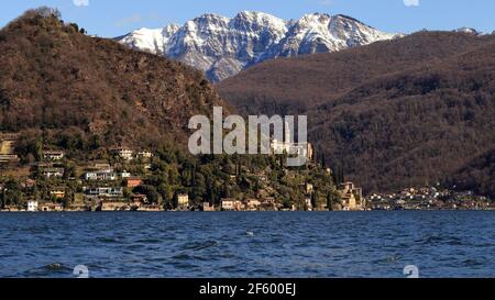 Blick auf das Dorf Morcote, italienische Schweiz, mit dem Luganersee und dem schneebedeckten Monte Generoso. Stockfoto