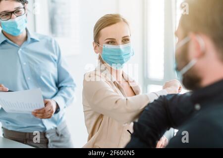 Geschäftsleute, die Corona Bump tun, um sich gegenseitig zu begrüßen Besprechung Stockfoto