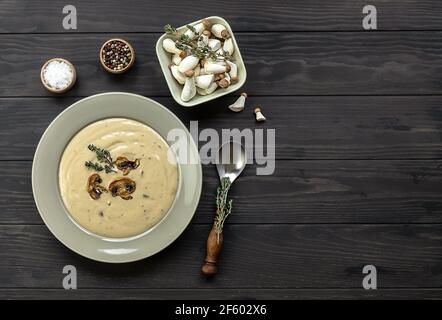 Köstliche Pilzsahnesuppe mit Thymen auf dem Holztisch. Horizontale Draufsicht von oben Stockfoto