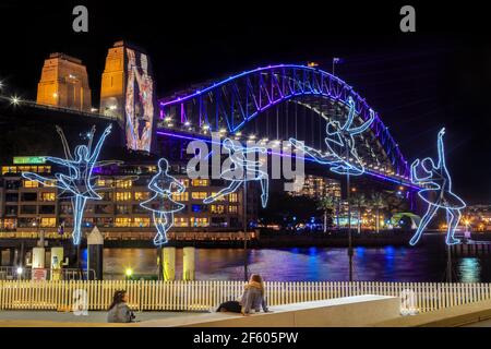 Sydney, Australien, während des jährlichen „Vivid Sydney“-Lichtfestivals. Eine Lichtskulptur namens „Ballerina“ vor der Sydney Harbour Bridge Stockfoto