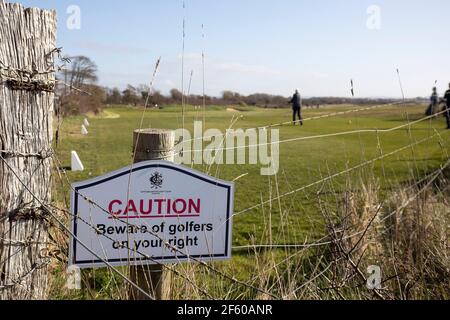 Littlehampton, Großbritannien. 29th. März 2021. Golfer spielen im Littlehampton Golf Club neben einem Schild, das sagt: "Vorsicht vor Golfern" nach Lockerung der Covid-19 Beschränkungen, die Sport draußen wieder aufnehmen. Bildnachweis: Paul Terry Kredit: Paul Terry Foto/Alamy Live Nachrichten Stockfoto