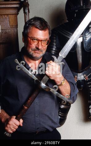 Schatzsucher und Enteuerer Hans Jörg Jacobi, der auf der Suche nach dem Nibelungenhort ist, mit einem historischen Schwert in seiner Wohnung in Mainz, Deutschland 1992. Stockfoto