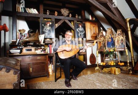 Schatzsucher und Abenteuerer Hans Jörg Jacobi, der auf der Suche nach dem Nibelungenhort ist, spielt die Laute in seiner Wohnung in Mainz, Deutschland 1992. Stockfoto