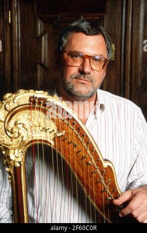 Schatzsucher und Abenteuerer Hans Jörg Jacobi, der auf der Suche nach dem Nibelungenhort ist, mit einer Harfe in seiner Wohnung in Mainz, Deutschland 1992. Stockfoto