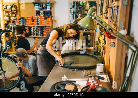 Männliche und weibliche Mechaniker reparieren Fahrrad in Reparaturwerkstatt Stockfoto