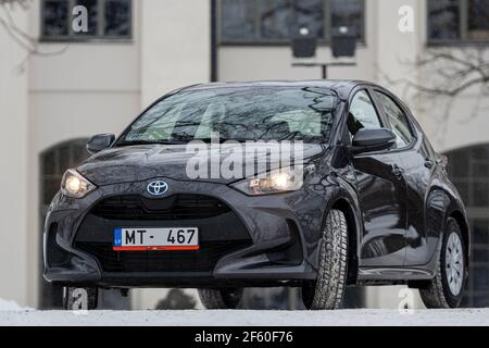 Riga, Lettland - 9. Februar 2021: Metallisch grauToyota Yaris Hybrid Y20 Edition Hatchback Auto in der Nähe des Wohnhauses geparkt Stockfoto