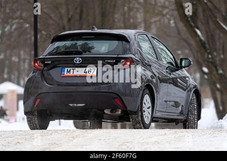 Riga, Lettland - 9. Februar 2021: Metallisch grauToyota Yaris Hybrid Y20 Edition Hatchback Auto in der Nähe des Wohnhauses geparkt Stockfoto