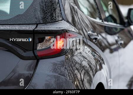 Riga, Lettland - 9. Februar 2021: Grau metallischer Toyota Yaris Hybrid Y20 Edition Hatchback, Nahaufnahme von Autoscheinwerfern Stockfoto