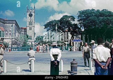 Crowd Scenes in Bridgetown, Barbados, 1955, während der Karibik-Tour von Prinzessin Margaret. Hier ist ein Willkommensschild vor den neugotischen Parlamentsgebäuden auf dem Parliament Square zu sehen. Im Januar 1955 machte die Prinzessin die erste von vielen Reisen in die Karibik, ihre Tour an Bord von Britannia zu den britischen Kolonien war in ganz Westindien beliebt. Prinzessin Margaret (1930 – 2002) war die jüngere Tochter von König Georg VI. Und Königin Elizabeth und die Schwester von Königin Elizabeth II. Dieses Bild stammt von einem alten Amateur-35-mm-Farbtransparenz – einem Vintage-Foto aus den 1950er Jahren. Stockfoto