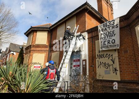 London, Großbritannien. März 2021, 29th. Gerichtsvollzieher entfernen Protestbanner von der Außenseite der Polizeistation. Die Polizeiwache war seit über einer Woche von Besetzern und autonomen Aktivisten unter dem Namen ‘Not A Cop Shop’ besetzt worden, im Gegensatz zu dem neuen ‘Police, Crime, Urteilsverkündung und Courts Bill’ und Feminizid. Cavendish Road Police Station, Clapham, London, Vereinigtes Königreich. Kredit: Joshua Windsor/Alamy Live Nachrichten. Stockfoto