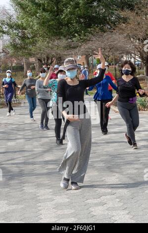 Ein schlanker anmutiger chinesisch-amerikanischer Lehrer unterrichtet in einem Park in Queens, New York City, eine Tanzübung. Stockfoto