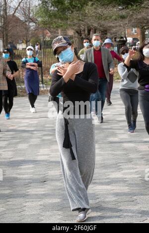 Ein schlanker anmutiger chinesisch-amerikanischer Lehrer unterrichtet in einem Park in Queens, New York City, eine Tanzübung. Stockfoto