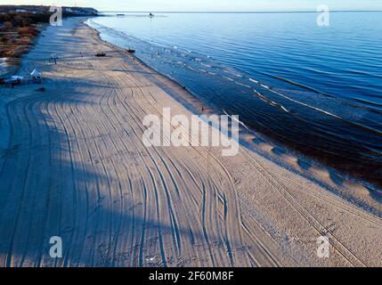 Ahlbeck, Deutschland. März 2021, 22nd. Am fast menschenleeren Strand wirft die untergehende Sonne lange Schatten von den Bäumen. (Luftaufnahme mit Drohne) Quelle: Jens Büttner/dpa-Zentralbild/ZB/dpa/Alamy Live News Stockfoto