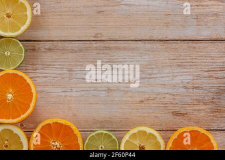 Orangen, Limetten und Zitronen Rutschen auf Holztisch Blick von oben. Wunderschön Hintergrund mit frischem Obst halb geschnitten.gesunde Ernährung Vitamin C.Sommer tropic Stockfoto