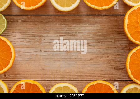 Orangen, Limetten und Zitronen Rutschen auf Holztisch Blick von oben. Wunderschön Hintergrund mit frischem Obst halb geschnitten.gesunde Ernährung Vitamin C.Sommer tropic Stockfoto