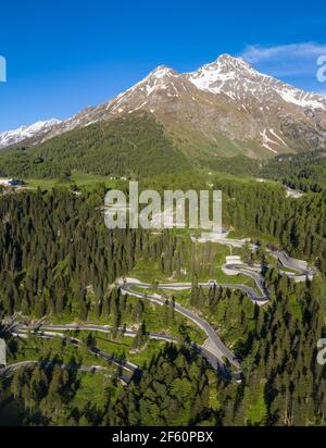 Dramatische Luftaufnahme der Malojapassstraße im Engadin in den alpen im Kanton Graubünden in der Schweiz an einem sonnigen Sommertag. Stockfoto