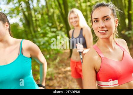 Sportliche junge Frau beim nordic Walking mit Freundinnen für Fitness Und Ausdauer Stockfoto