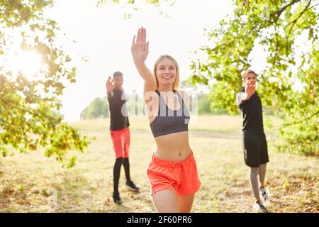 Gruppe von jungen Leuten hat Spaß dabei Tanzturnen in Aerobic-Kurs in der Natur Stockfoto