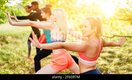 Gruppe von Freunden tun Tai Chi zusammen in Fitness-Klasse In der Natur im Sommer Stockfoto