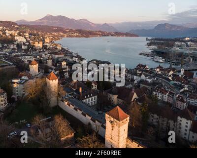 Luftaufnahme des Sonnenuntergangs über der berühmten Luzerner Altstadt Stadt und seine befestigten Mauern in der Zentralschweiz mit See Luzern und alpen Berg im b Stockfoto