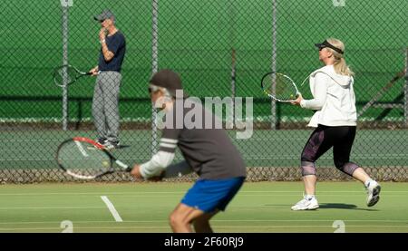 Bournemouth, Großbritannien. 29th. März 2021. Menschen genießen ein Tennisspiel in der Sonne im Bournemouth Gardens Tennis Center am ersten Tag der Outdoor-Sport erlaubt als Teil der Lockerung der Beschränkungen nach der dritten nationalen Sperre der Covid-19 Pandemie. . Kredit: Richard Crease/Alamy Live Nachrichten Stockfoto