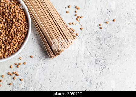 Rohe Soba - Buchweizennudeln und Buchweizen in einer weißen Schüssel. Gesunde Ernährung Konzept. Stockfoto