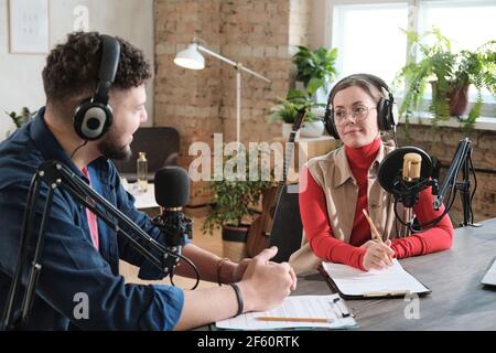 Podcasts sprechen mit Mikrofonen, die Podcast im Studio aufnehmen Stockfoto