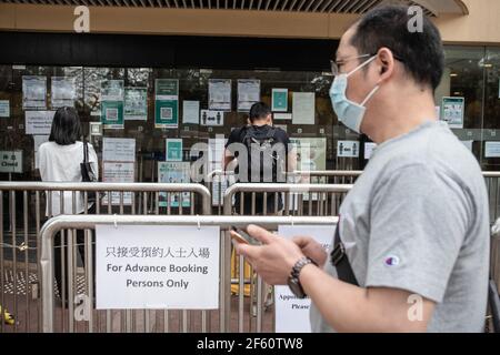 Hongkong, China. März 2021, 18th. Die Menschen warten in der Schlange, um das Gemeinschafts-Impfzentrum zu besuchen, das in einer der Galerien der Zentralbibliothek von Hongkong im Tai Hang-Bezirk eingerichtet ist. Bürger Hongkongs besuchen am Donnerstag, den 18th. März, das Gemeinschafts-Impfzentrum, das in einer der Galerien der Zentralbibliothek Hongkongs im Tai Hang-Bezirk eingerichtet ist. Kredit: SOPA Images Limited/Alamy Live Nachrichten Stockfoto