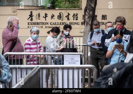 Hongkong, China. März 2021, 18th. Die Menschen warten in der Schlange, um das Gemeinschafts-Impfzentrum zu besuchen, das in einer der Galerien der Zentralbibliothek von Hongkong im Tai Hang-Bezirk eingerichtet ist. Bürger Hongkongs besuchen am Donnerstag, den 18th. März, das Gemeinschafts-Impfzentrum, das in einer der Galerien der Zentralbibliothek Hongkongs im Tai Hang-Bezirk eingerichtet ist. Kredit: SOPA Images Limited/Alamy Live Nachrichten Stockfoto