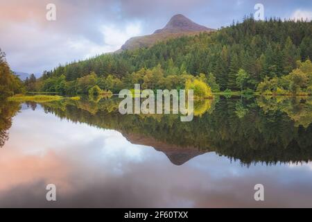 Ruhige, idyllische Berglandschaft See Reflexion des Pap von Glencoe auf Glencoe Lochan bei Sonnenuntergang oder Sonnenaufgang in den schottischen Highlands, Schottland. Stockfoto