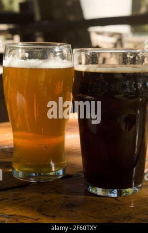 Tisch serviert mit zwei Gläsern Bier, schwarz und blond, Lager und Stout im Biergarten, natürlich Stockfoto