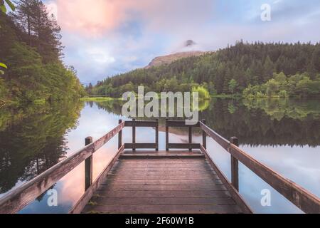 Ruhige, idyllische Berglandschaft Blick auf den See Glencoe Lochan bei einem bunten Sonnenuntergang oder Sonnenaufgang in den schottischen Highlands, Schottland. Stockfoto