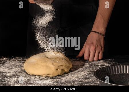 Hausgemachtes Brot. Schritt-für-Schritt-Anleitung. Der Koch formt den Teig. Holzhintergrund. Stockfoto