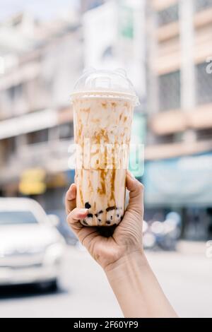 Bubble Ball Eis Milch Tee in der Hand mit Blur Asia Gebäude Hintergrund. Stockfoto