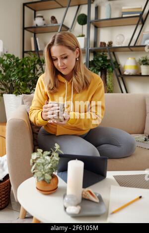 Ziemlich kreative junge Frau mit Blick auf duftende Cande sie gemacht Stockfoto