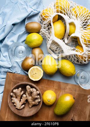 Zitrusfrüchte im Netzbeutel mit Ingwerwurzeln Stockfoto