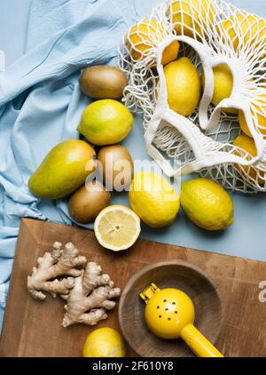 Zitrusfrüchte im Netzbeutel mit Ingwerwurzeln Stockfoto